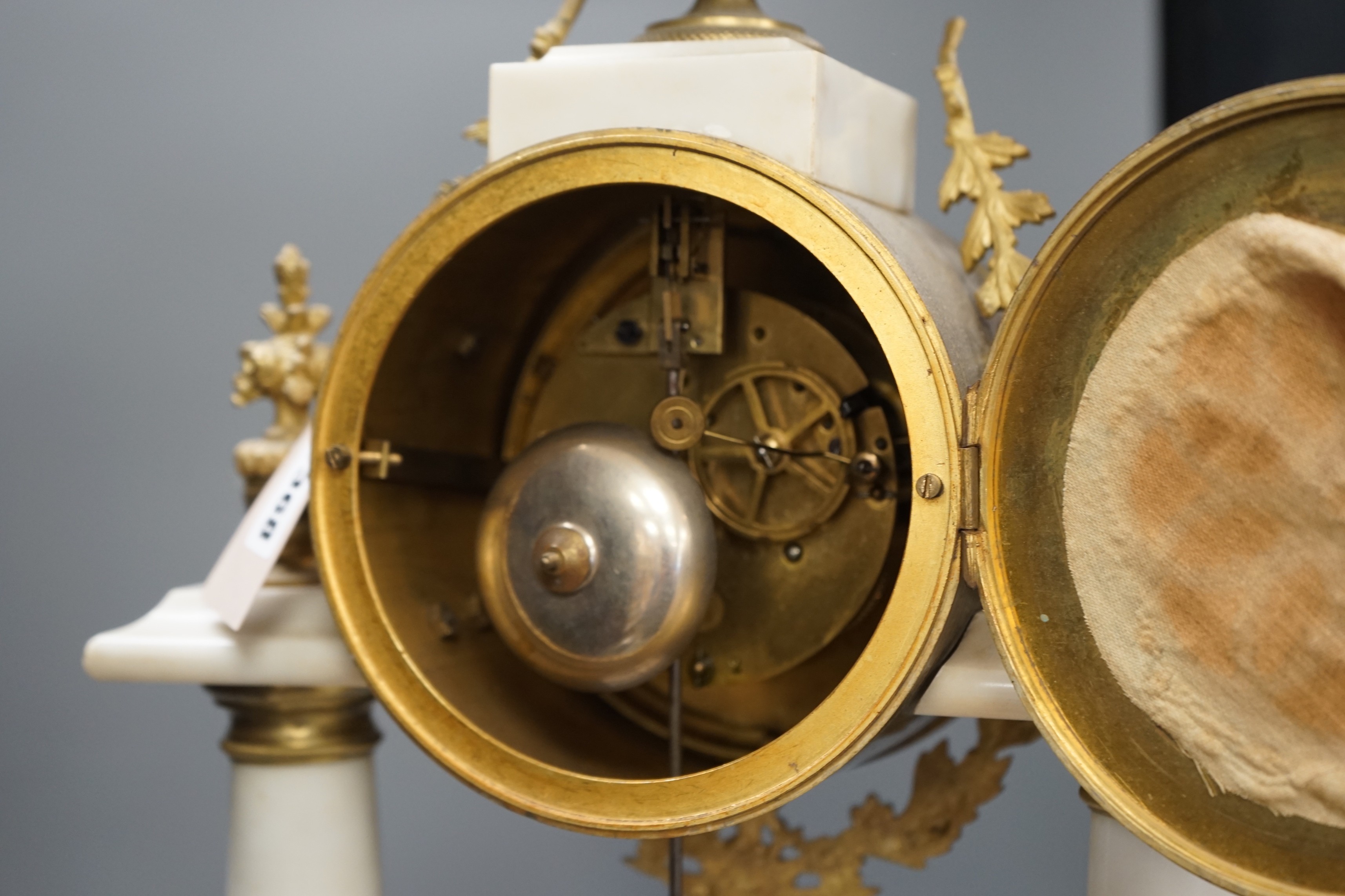 A large French white marble portico clock with ormolu decoration and sunburst pendulum, 59.5cm tall